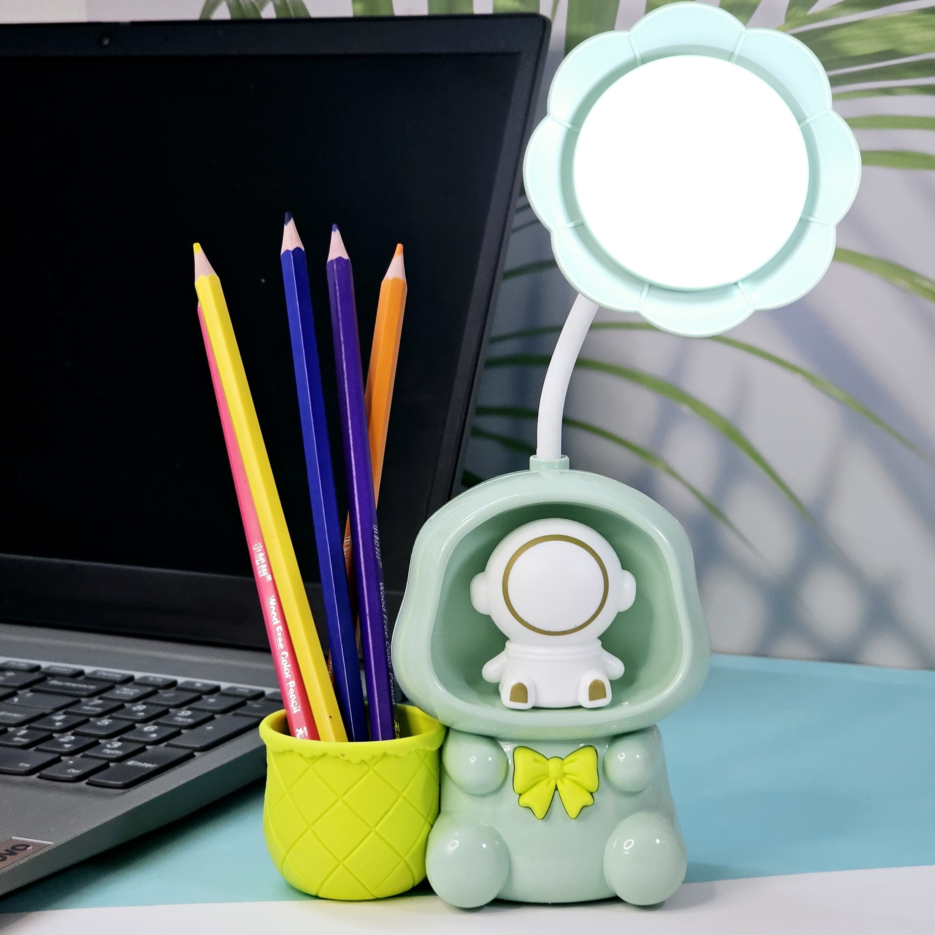 Colorful Usmile Toys children's desk lamps, shaped like cute astronauts with light-up heads and built-in compartments for pencils, ideal for a child's study area or bedroom."www.usmile.toys